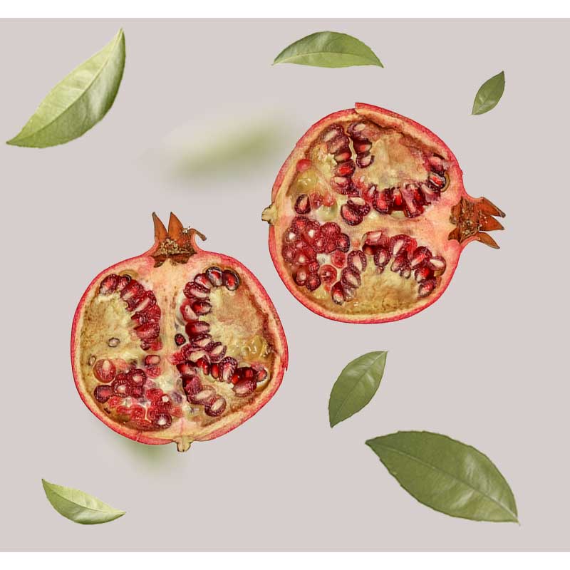 granatapfel Granatapfelhälften mit saftigen Kernen und grünen Blättern, symbolisierend die natürlichen Inhaltsstoffe des RAU Beyond Herbal Tonic für Hautpflege.