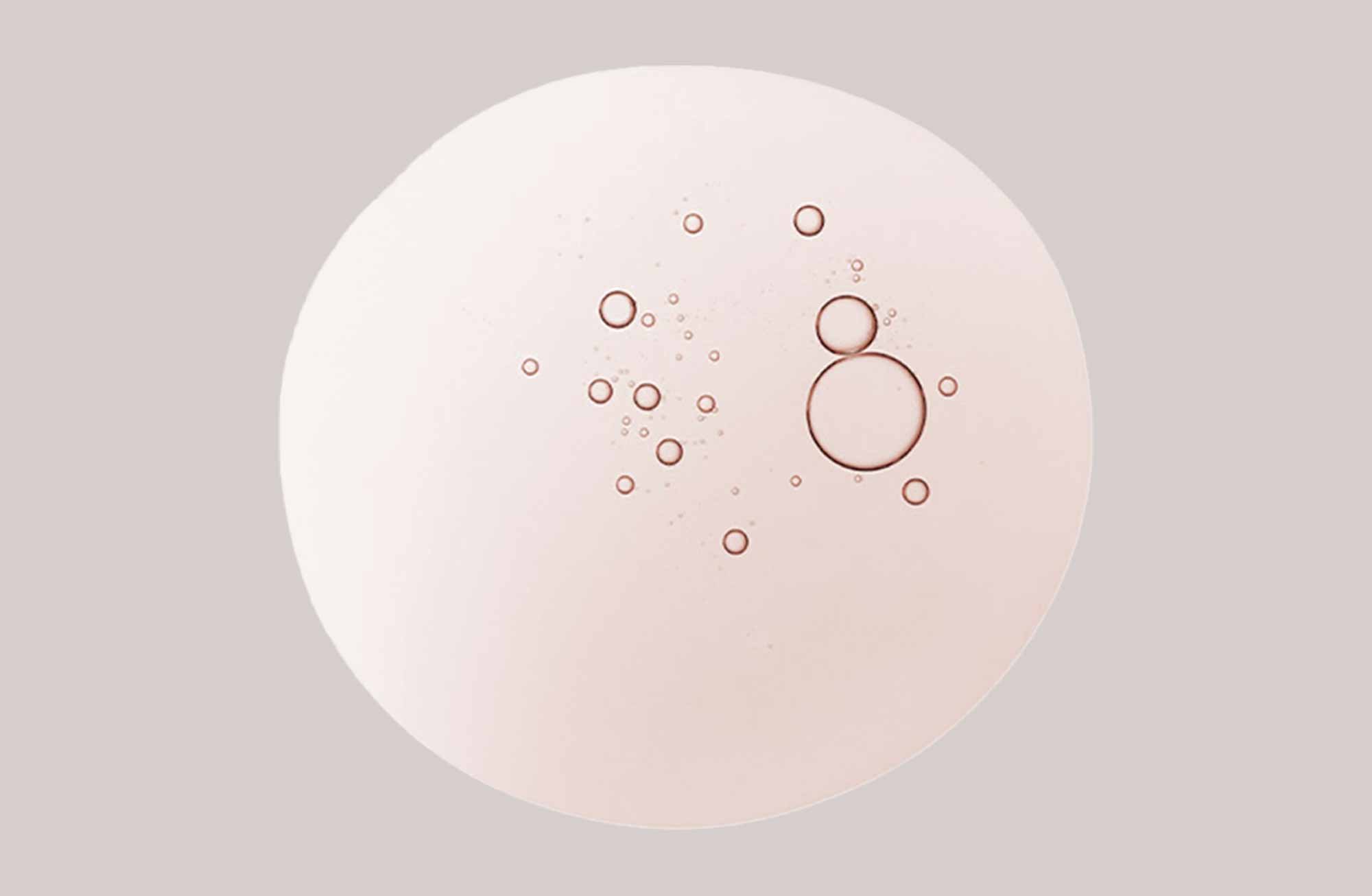 Minimalistische Grafik mit kreisförmigem Design und Blasen, die den Deep Cleansing 2in1 Facial Toner von RAU Cosmetics zeigt.