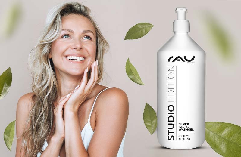 Lächelnde Frau mit RAV STUDIO EDITION SILVER FACIAL WASH und grünen Blättern, ideal für die Hautpflege.