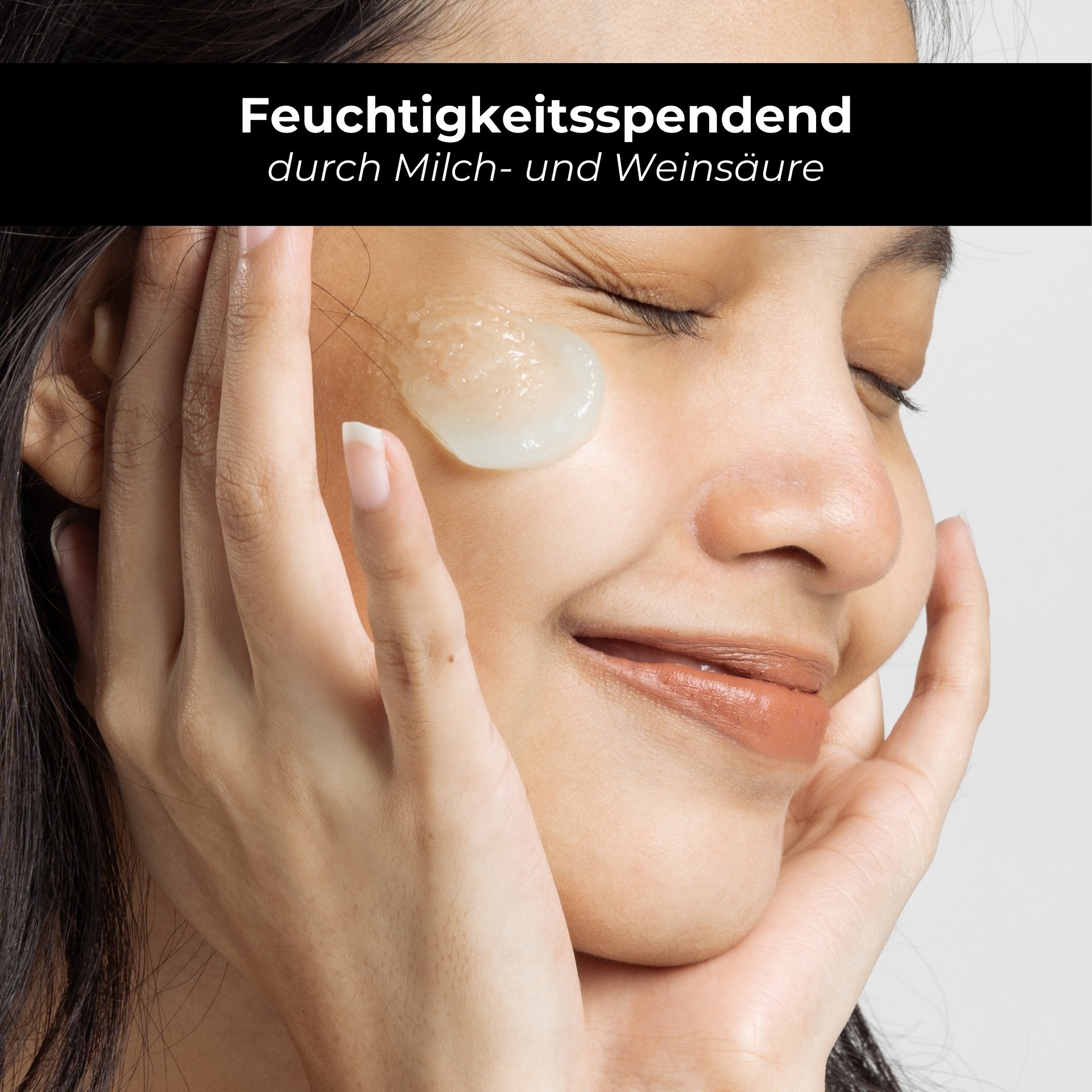 Woman with moisturizing gel on her face, smiling, showing application of skincare products with lactic and tartaric acid.