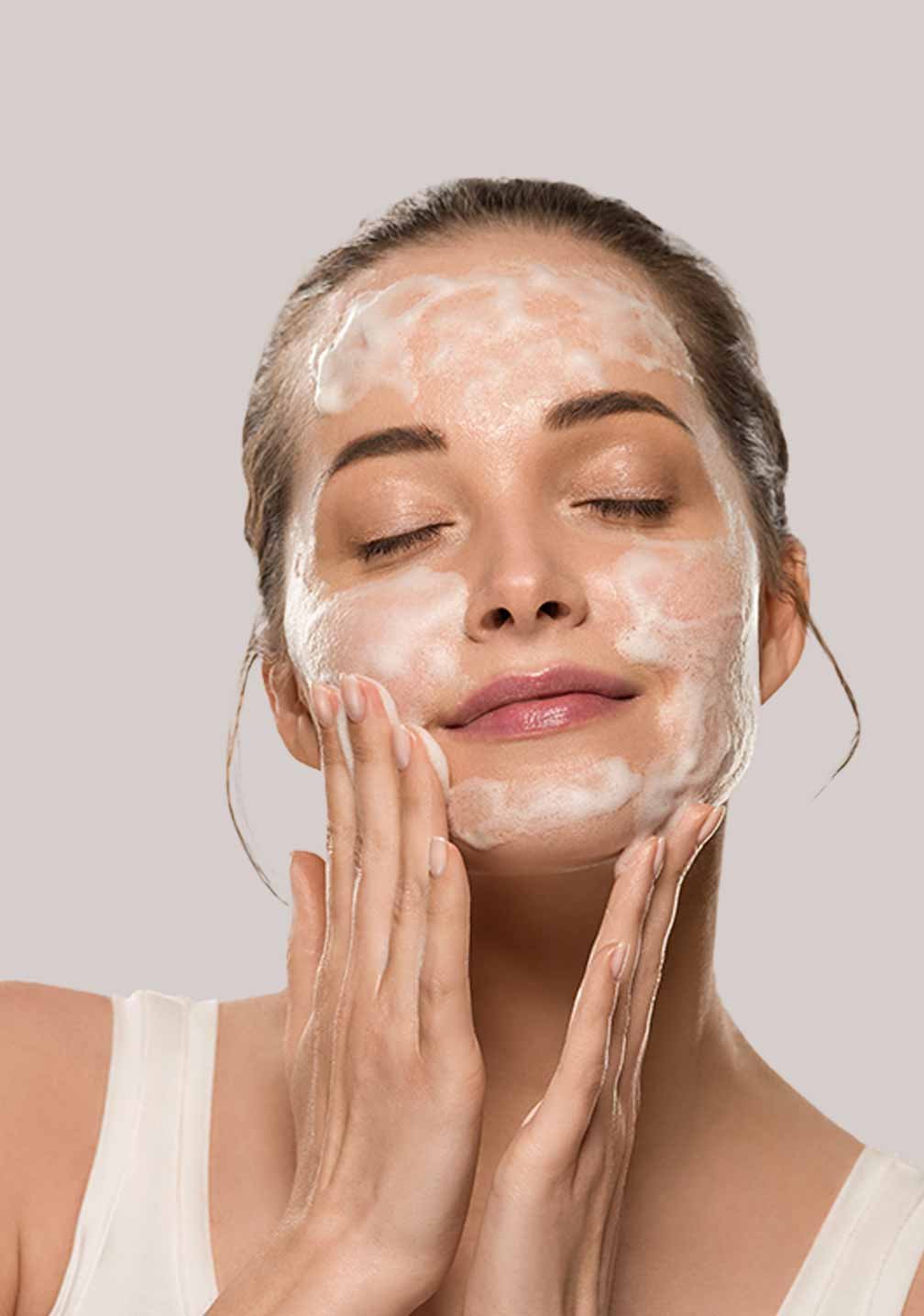 Frau, die ein Gesichtsreiniger-Foam anwendet, für RAU Cosmetics Gesichtswäsche gegen Akne und Unreinheiten.